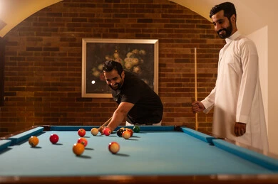 صاله رياضيه شبابيه، متعه وترفيه, منافسات وتحديات, لاعبين محترفين, حوار ومناقشة بين الأصدقاء، مقهى البلياردو, أنشطه وهوايات شبابيه, طاولة بلياردو (السنوكر), مجموعه من الشباب العرب السعوديون الخليجيون يرتدون ملابس كاجوال والزي التقليدي, يلعبون لعبة البلياردو