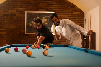 عطلة نهاية الاسبوع مع الاصدقاء، لاعبين محترفين, حوار ومناقشة بين الأصدقاء، مقهى البلياردو, أنشطه وهوايات شبابيه, طاولة بلياردو (السنوكر), مجموعه من الشباب العرب السعوديون الخليجيون يرتدون ملابس كاجوال والزي التقليدي, يلعبون لعبة البلياردو، صاله رياضيه شبابيه