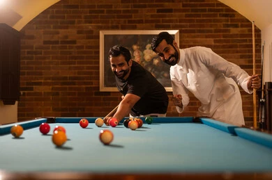الروح الرياضية بين الاصدقاء، لاعبين محترفين, حوار ومناقشة بين الأصدقاء، مقهى البلياردو, أنشطه وهوايات شبابيه, طاولة بلياردو (السنوكر), مجموعه من الشباب العرب السعوديون الخليجيون يرتدون ملابس كاجوال والزي التقليدي, يلعبون لعبة البلياردو، صاله رياضيه شبابيه