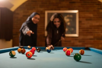الاماكن الانيقة والحديثة مع طاولة بلياردو ، لاعبين محترفين, حوار ومناقشة بين الأصدقاء، مقهى البلياردو, أنشطه وهوايات شبابيه, طاولة بلياردو (السنوكر), مجموعه من السيدات العرب السعوديون الخليجيون يرتدون العباءة واحدهم ترتدي الحجاب, يلعبون لعبة البلياردو، صاله رياضيه شبابيه