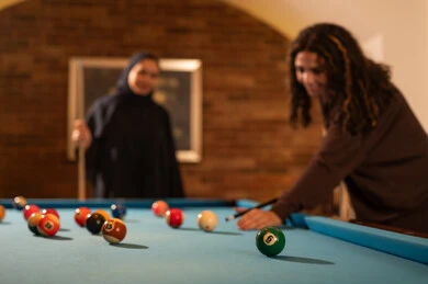 التركيز والهدوء والتصويب، لاعبين محترفين, حوار ومناقشة بين الأصدقاء، مقهى البلياردو, أنشطه وهوايات شبابيه, طاولة بلياردو (السنوكر), مجموعه من السيدات العرب السعوديون الخليجيون يرتدون العباءة واحدهم ترتدي الحجاب, يلعبون لعبة البلياردو، صاله رياضيه شبابيه