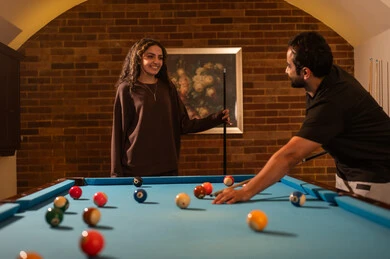 تحسين العلاقة بين الشريكين , العلاقات الزوجية الناجحة،  الاوقات المفضلة بين الازواج،  حوار ومناقشة بين الأصدقاء، مقهى البلياردو, طاولة بلياردو (السنوكر), رجل وزوجته عرب سعوديون خليجيون يرتدي يرتدي الزي الكاجوال يلعبون لعبة البلياردو، صاله رياضيه شبابيه