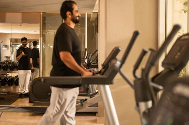 استخدام الأجهزة الرياضية، نشاط شبابي يساعد على المرونة البدنية,  أهمية الرياضة لبناء جسد قوي، الاهتمام بالصحة واللياقة الجسدية، رجل سعودي يمارس تمرين لتحسين وضعية الجسم والتوازن، شاب عربي خليجي سعودي يرتدي الزي الرياضي يقوم بممارسة التمارين على جهاز المشي