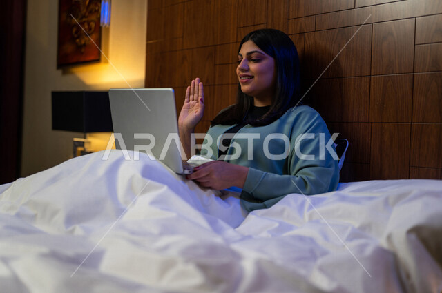 A Saudi Arabian Gulf woman, making a video chat using her laptop, social networking and chatting, using modern technologies.