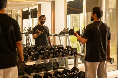 Healthy lifestyle system, practicing favorite sports with friends, the importance of sports for building a strong body, paying attention to health and physical fitness, a Saudi man practicing exercises to improve body posture and balance, a young Arab Gulf Saudi wearing sportswear doing exercises and lifting weights.