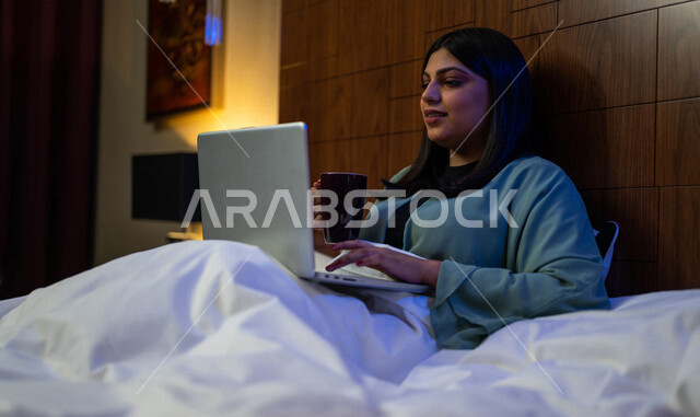 A Saudi Arabian Gulf woman, making a video chat using her laptop, social networking and chatting, using modern technologies.