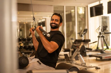 الاهتمام بالصحة واللياقة الجسدية، إيماءات القوة والثقة، رياضة كمال الأجسام، أسلوب حياة صحي، استخدام الأجهزة الرياضية، شاب عربي خليجي سعودي يرتدي الزي الرياضي يقوم بممارسة تمارين رفع الأوزان، رجل سعودي يمارس أنشطة لتقوية العضلات