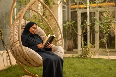 قضاء وقت الفراغ في مطالعة الكتب والروايات، شابة عربية خليجية سعودية ترتدي عباءة تجلس على الارجوحة تقوم بقراءة كتاب، قضاء وقت ممتع في الهواء الطلق في احدى الشاليهات السياحية قضاء وقت الفراغ في مطالعة الكتب والروايات، شابة عربية خليجية سعودية ترتدي عباءة تجلس على الارجوحة تقوم بقراءة كتاب، قضاء وقت ممتع في الهواء الطلق في احدى الشاليهات السياحية