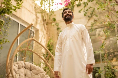 Gestures of happiness and joy, solitude with oneself in quiet places to calm the nerves, a young Arab Gulf Saudi man wearing traditional attire in the garden, enjoying time outdoors in one of the tourist chalets in the Kingdom of Saudi Arabia. Gestures of happiness and joy, solitude with oneself in quiet places to calm the nerves, a young Arab Gulf Saudi man wearing traditional attire in the garden, enjoying time outdoors in one of the tourist chalets in the Kingdom of Saudi Arabia.