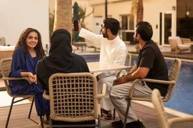 Taking a selfie, documenting happy moments with a picture, spending enjoyable family time, visiting relatives and family, recreational resorts and chalets in the Kingdom, a Saudi Gulf Arab family enjoying time in one of the tourist chalets, family entertainment activities, a fun summer vacation.