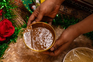 استخدام الحناء للتزيين والجمال، صورة مقربة ليد امراه عربية خليجيه اماراتية تقوم  بإعداد خليط الحناء الطبيعي وتغطيته بالبلاستيك للحفاظ عليه، تقاليد وعادات عربية قديمة