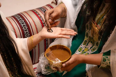 التجمل بالمظهر الشعبي الأصيل، زخارف وفنون يدويه من مواد طبيعيه، عادات وتقاليد في المناسبات والأفراح السعيدة، تصوير مقرب ليد إمرأة عربية خليجية إماراتية تقوم برسم و نقش الحنة على يد العروس ، مهن وأزياء تقليدية شعبية نسائية