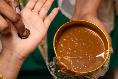 الصناعات الحرفية المحلية التراثية، مهن وأزياء تقليدية شعبية نسائية، مظاهر الفرح والسرور في الأعراس، تقاليد الزواج والاحتفال الخليجي، الاستعداد للمناسبات السعيدة، تصوير مقرب ليد إمرأة عربية خليجية إماراتية تقوم برسم و نقش الحنة على يد العروس