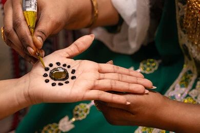 تجهيز العروس ليلة الزفاف، تقاليد الزواج والاحتفال الخليجي، الاستعداد للمناسبات السعيدة، زخارف وفنون يدويه من مواد طبيعيه، تصوير مقرب ليد إمرأة عربية خليجية إماراتية تقوم برسم و نقش الحنة على يد العروس ، مهن وأزياء تقليدية شعبية نسائية