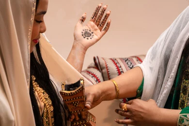The elegance of musk and oud perfume, the authenticity of Gulf customs and traditions, the celebration of occasions and happy events, an Arab Gulf Emirati woman wearing traditional attire holding a incense burner (mabkharah) to perfume the bride, wedding and marriage ceremonies.