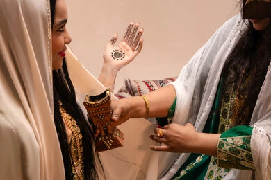 Wearing oriental perfumes, the authenticity of Gulf customs and traditions, celebrating occasions and happy events, an Emirati Gulf Arab woman dressed in traditional attire holding a incense burner (mabkharah) to perfume the bride, wedding and marriage ceremonies.