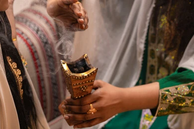 Eastern incense and perfumes, the authenticity of Gulf customs and traditions, celebrating occasions and happy events. An Emirati Gulf Arab woman wearing traditional attire holds a incense burner (mabkhara) in her hand and is perfuming the bride, the rituals of weddings and marriage. Eastern incense and perfumes, the authenticity of Gulf customs and traditions, celebrating occasions and happy events. An Emirati Gulf Arab woman wearing traditional attire holds a incense burner (mabkhara) in her hand and is perfuming the bride, the rituals of weddings and marriage.