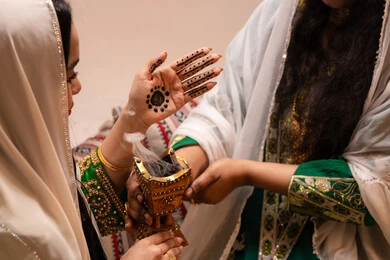 التعطر بروائح العود والمسك، أصالة العادات والتقاليد الخليجية، الاحتفال بالمناسبات والأفراح السعيدة, امراة عربية خليجية اماراتية ترتدي الزي الشعبي تحمل بيدها حامل البخور( المبخرة ) تقوم بتبخير العروس، مراسم الأعراس والزواج