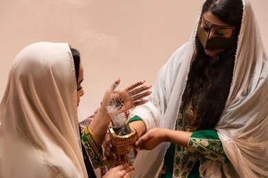 The authenticity of Gulf customs and traditions, celebrating occasions and happy events, an Emirati Gulf Arab woman wearing traditional attire holding a incense holder (mabkharah) in her hand, performing incense for the bride, applying perfume with musk and oud, wedding and marriage ceremonies.