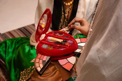 منتجات ومساحيق التجميل، ارتداء الازياء التقليدية، مفهوم التزين والاطلالة المتألقة، العناية بالجمال و الانوثة، الاحتفال بليلة العمر, مناسبات وأفراح واحتفالات سعيدة، صورة مقربه ليد سيدة عربية خليجية اماراتية تقوم بوضع المكياج للعروسة