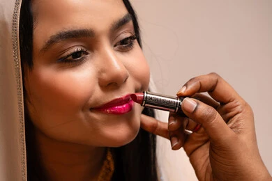 منتجات ومساحيق التجميل, مناسبات وأفراح واحتفالات سعيدة، العناية والاهتمام بالأناقة والجمال، مفهوم التزين والاطلالة المتألقة،صورة مقربة سيدة عربية خليجية اماراتية تقوم بوضع أحمر الشفاه للعروسة، إيماءات السعادة والفرح ، الاحتفال بليلة العمر