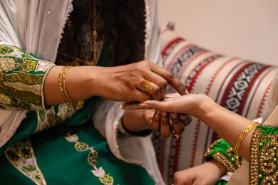 الاستعداد من اجل ليلة العمر، ازياء تقليدية شعبية نسائية، عادات وتقاليد في المناسبات والأفراح السعيدة، الاهتمام بالأناقة والمظهر الخارجي, بورترية مقرب ليد امرأة عربية خليجية إماراتية ترتدي الزي الشعبي تقوم برسم الحنه على يد العروسة, شابة سعودية تقوم بالتزين والتجمل في يوم زفافها، خلفية بني