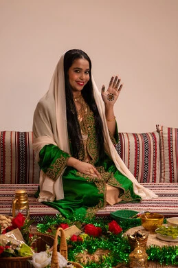 فنون ونقوش وزخارف يدويه من مواد طبيعيه، الاستعدادات لليلة الزفاف، الزينة الاماراتية التقليدية للعروس، عادات وتقاليد في المناسبات والأفراح السعيدة، إمرأة عربية خليجية إماراتية ترتدي العباءة المطرزة  تنظر الى الكاميرا بايماءات السعادة و السرور