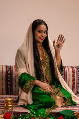 الاستعدادات لليلة الزفاف، الزينة الاماراتية التقليدية للعروس، فنون ونقوش وزخارف يدويه من مواد طبيعيه، عادات وتقاليد في المناسبات والأفراح السعيدة، إمرأة عربية خليجية إماراتية ترتدي العباءة المطرزة  تنظر الى الكاميرا بايماءات السعادة و السرور