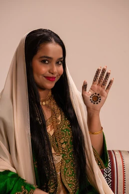 الزينة الاماراتية التقليدية للعروس، الاستعدادات لليلة الزفاف، فنون ونقوش وزخارف يدويه من مواد طبيعيه، عادات وتقاليد في المناسبات والأفراح السعيدة، إمرأة عربية خليجية إماراتية ترتدي العباءة المطرزة  تنظر الى الكاميرا بايماءات السعادة و السرور