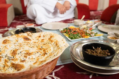 The values and traditions of Arab hospitality, a close-up image of a table filled with delicious Eastern dishes, the concept of generosity and good reception, sharing food in a spirit of warmth and closeness.