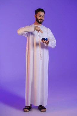 تدليك و ترطيب الوجه، بورتريه لرجل عربي خليجي اماراتي يرتدي الكندورة الاماراتية و يضع على وجهه كريم المرطب, استخدام مكونات تجميلية شبابية، مفهوم العناية والإهتمام بنضارة وتحسين البشرة، خلفية بنفسجية