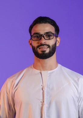 Seeing through the lenses, gestures of happiness and pleasure with the clarity of the image, trying to adjust vision, portrait of a smiling Emirati Gulf Arab man wearing the Emirati kandura and wearing medical glasses, purple background