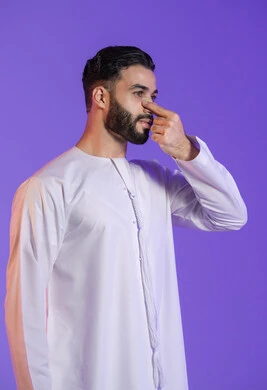 تنظيف لطيف للأنف, إزالة الرؤوس السوداء بسهولة, منتجات تجميلية فعالة وتقنيات حديثة، وعي الرجل العربي بأهمية العناية الشخصية، بورتريه مقرب لرجل عربي خليجي اماراتي يرتدي الكندورة الاماراتية و يقوم بوضع ماسك على أنفه, خلفية بنفسجية