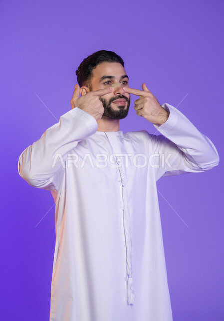 التخلص من الشوائب والدهون, إزالة الرؤوس السوداء بسهولة, منتجات تجميلية فعالة وتقنيات حديثة، وعي الرجل العربي بأهمية العناية الشخصية، بورتريه مقرب لرجل عربي خليجي اماراتي يرتدي الكندورة الاماراتية و يقوم بوضع ماسك على أنفه, خلفية بنفسجية