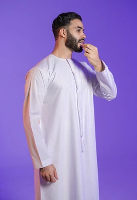 أداة عناية بالفم, الحفاظ على النظافة بخيط سني بلاستيكي, التأكد من نظافة الأسنان بعد تناول الطعام، المحافظة على ابتسامة ناصعة البياض، بورتريه لرجل عربي خليجي اماراتي يرتدي الكندورة الاماراتية و يقوم بتنظيف أسنانه,  خلفية بنفسجية