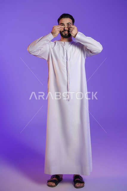 وعي الرجل العربي بأهمية العناية الشخصية، منتجات تجميلية فعالة وتقنيات حديثة، التخلص من الرؤوس السوداء والجلد الميت، بورتريه لرجل عربي خليجي اماراتي يرتدي الكندورة الاماراتية و يقوم بوضع ماسك على أنفه, خلفية بنفسجية