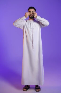 Arab man's awareness of the importance of personal care, effective cosmetic products and modern techniques, getting rid of blackheads and dead skin, portrait of an Emirati Gulf Arab man wearing an Emirati kandura and putting a mask on his nose, purple background