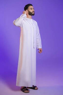 Using ear swabs safely, daily ear hygiene routine, portrait of an Emirati Gulf Arab man wearing an Emirati kandura and holding a cotton swab, purple background