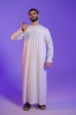 منتجات العطور الفاخرة,  استخدام الزيوت العطرية الطبيعية, مفهوم الاناقة والاهتمام بالمظهر الخارجي, بورتريه لرجل عربي خليجي اماراتي يرتدي الكندورة الاماراتية و يمسك زجاجة عطر, خلفية بنفسجية