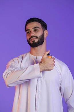 Emirati perfume products, use of natural essential oils, concept of elegance and interest in outward appearance, portrait of an Emirati Gulf Arab man wearing the Emirati kandura and holding a bottle of perfume, purple background