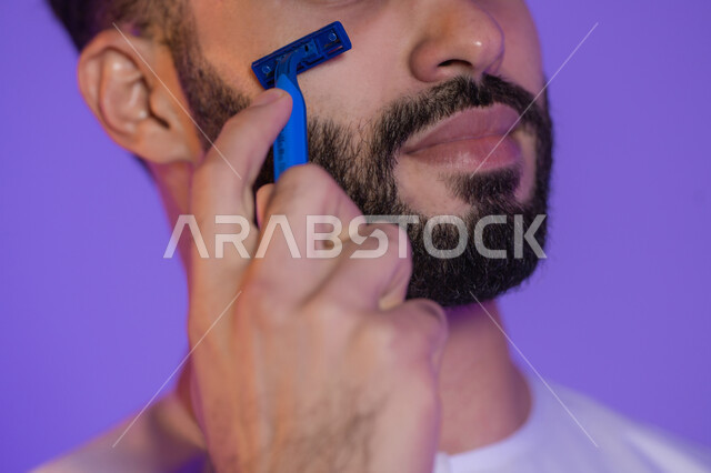 تجربة حلاقة سلسة ومريحة, العناية بالوجه قبل الانطلاق في اليوم, استخدام شفرة الرجالية، مفهوم الاعتناء بالبشرة والاهتمام بالمظهر الخارجي، المحافظة على الأناقة والنظافة، بورتريه لرجل عربي خليجي اماراتي, خلفية بنفسجية
