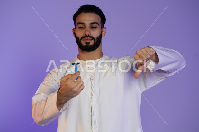 عدم الإعجاب وعدم الرضا, الحفاظ على الأناقة والنظافة الشخصية، العناية بالبشرة والاهتمام بالمظهر الخارجي، بورتريه لرجل عربي خليجي اماراتي يرتدي الكندورة الاماراتية و يمسك شفرة حلاقة, خلفية بنفسجية