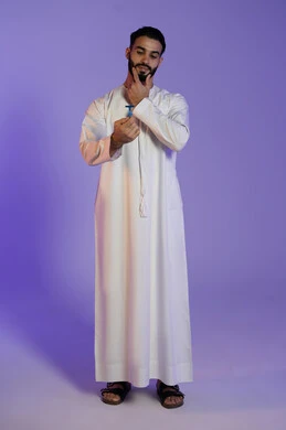 Final touch for a stylish look, a moment of concentration before shaving, maintaining elegance and personal hygiene, skin care and attention to one's appearance, portrait of an Emirati Gulf Arab man wearing the Emirati kandura and holding a razor, purple background