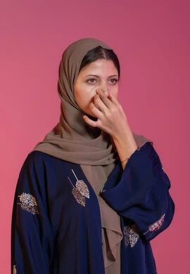 التخلص من الرؤوس السوداء والجلد الميت، بورتريه لامرأة عربية خليجية اماراتية محجبة تقوم بوضع لصقات الأنف، استخدام ماسكات تنظيف المسام ومكونات تجميلية نسائية، العناية والاهتمام بنضارة وتحسين البشرة، خلفية وردية