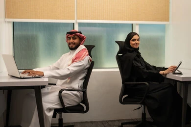تطوير أفكار جديدة للشركة, إدارة المهام اليومية بدقة, استخدام التكنولوجيا و التقنيات الحديثة, تطبيقات و برامج الأجهزة اللوحية، فريق عربي خليجي سعودي مكون من رجل يرتدي الثوب التقليدي و الشماغ و سيدة محجبة ترتدي العباءة السوداء