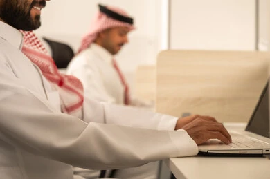 زملاء عمل عرب سعوديين خليجيين يستخدمون الحاسوب المحمول، أماكن مخصصة لكل موظف في الشركة، التركيز والعمل المتقن, الحوارات والنقاشات ضمن الفريق,تطوير الاعمال والشركات, اجتماع عمل وانجاز المشاريع, مناقشة الخطط وشرح مهام الاعمال
