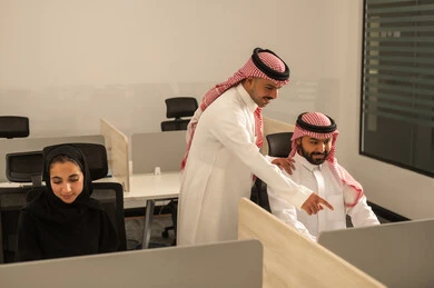 التركيز والعمل المتقن, شرح واعطاء الخبرات بين الزملاء،الحوارات والنقاشات ضمن الفريق,تطوير الاعمال والشركات, اجتماع عمل وانجاز المشاريع, مناقشة الخطط وشرح مهام الاعمال, زملاء عمل عرب سعوديين خليجيين يرتدون الزى التقليدي والشماغ يتبادلان الحديث