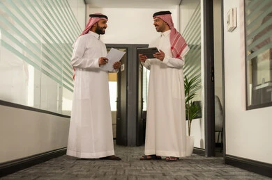 الحوارات والنقاشات ضمن الفريق, استخدام جهاز التابلت والحاسوب المحمول لانجاز المهام، التركيز والعمل المتقن,تطوير الاعمال والشركات, موظفين عربيين خليجيين سعوديين يجلسون داخل المكتب، مناقشة خطط المشاريع ،شرح مهام الاعمال