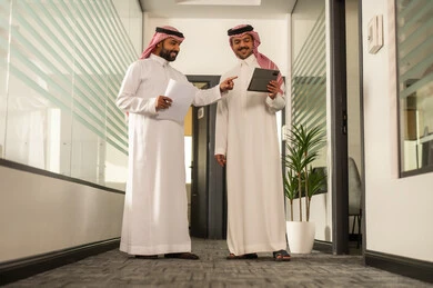 مناقشة خطط المشاريع ، استخدام جهاز التابلت والحاسوب المحمول لانجاز المهام، التركيز والعمل المتقن, الحوارات والنقاشات ضمن الفريق,تطوير الاعمال والشركات, موظفين عربيين خليجيين سعوديين يجلسون داخل المكتب،شرح مهام الاعمال