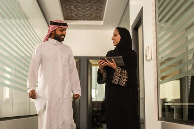 استخدام جهاز التابلت لانجاز المهام، التركيز والعمل المتقن, الحوارات والنقاشات ضمن الفريق,تطوير الاعمال والشركات, موظفين عربيين خليجيين سعوديين يجلسون داخل المكتب، مناقشة خطط المشاريع ،شرح مهام الاعمال